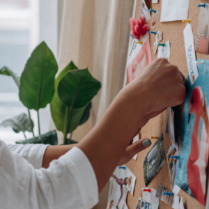 woman pinning items to vision board