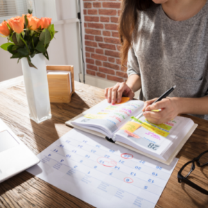 woman writing goals in planner