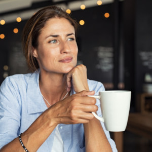 woman drinking coffee staring off as she thinks