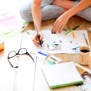 woman sitting on the floor creating her vision board